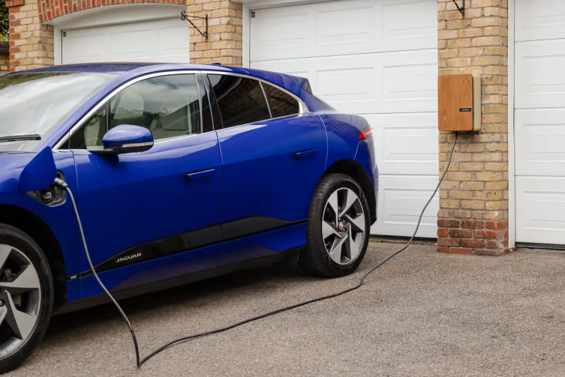 Elektrische auto laadt aan een laadpaal bij huis